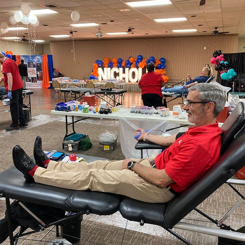 Jorge Martinez sitting on cot donating blood