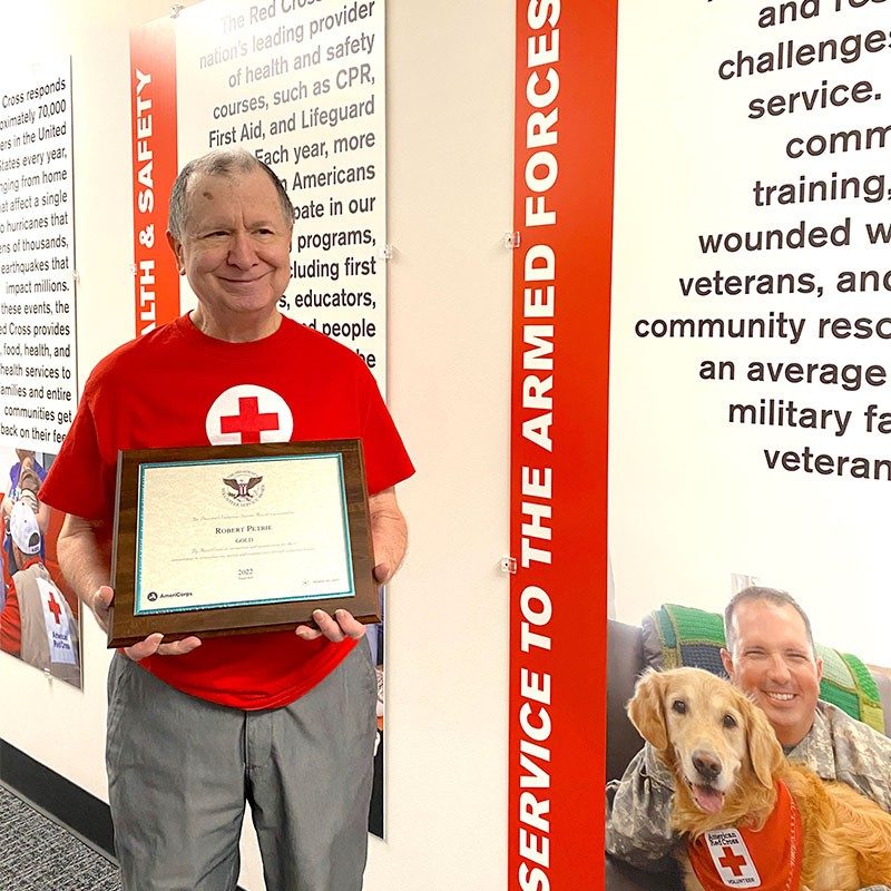 Red Cross volunteer Robert Petrie holding President’s Volunteer Service Award